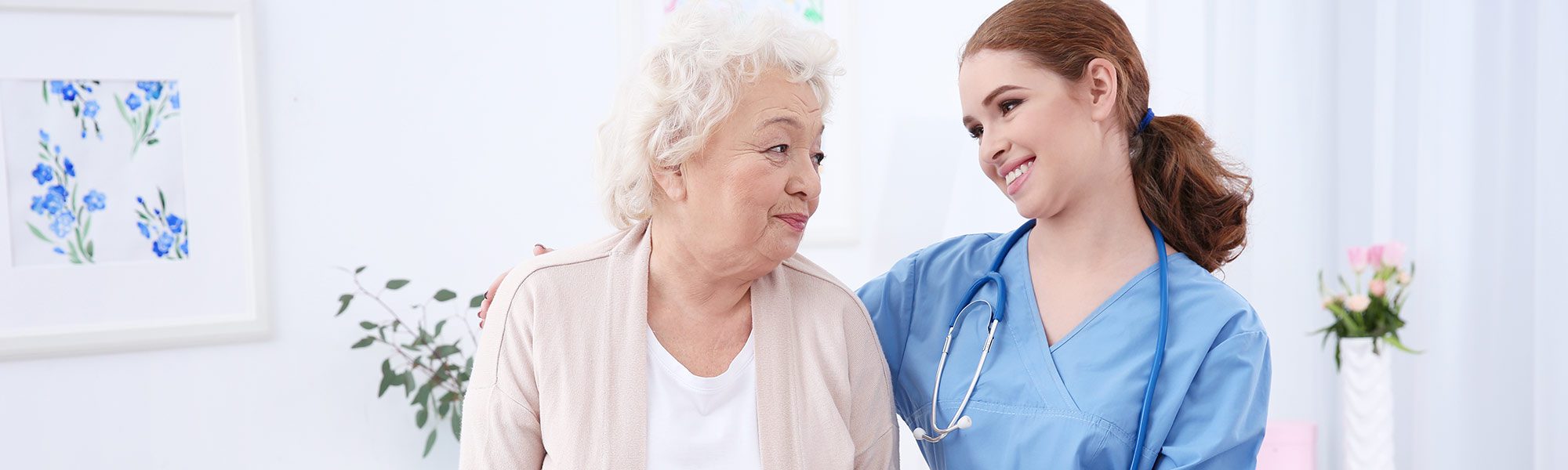Nurse and an older lady patient smiling at each other