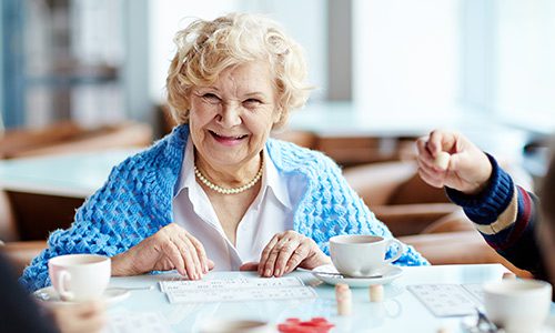 Older lady playing bingo and smiling